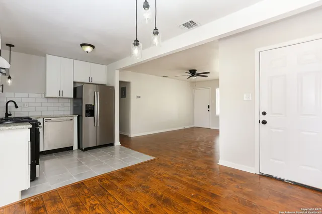 a view of kitchen with refrigerator cabinets and wooden floor