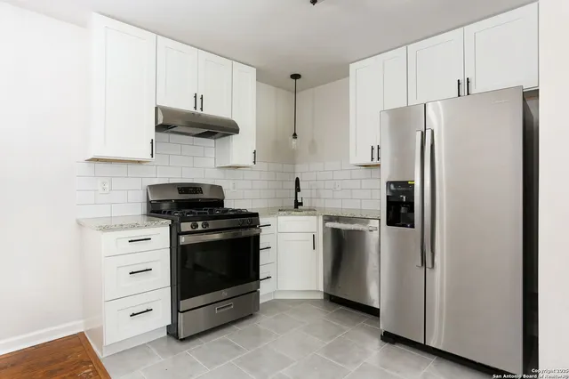a kitchen with stainless steel appliances white cabinets and a stove