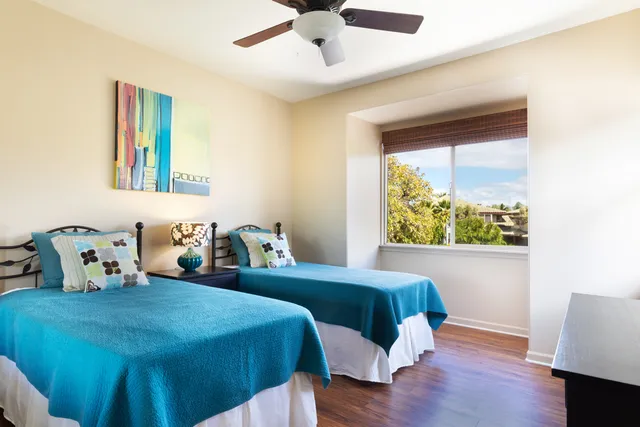 a bedroom with two beds and a large window