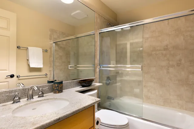 a bathroom with a granite countertop sink toilet and shower