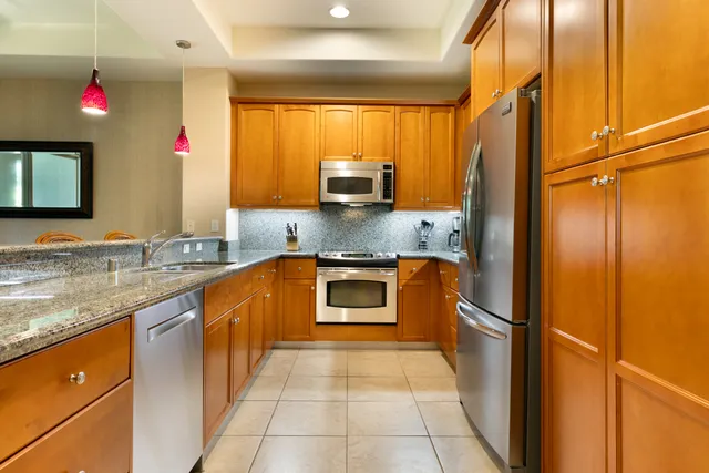 a kitchen with granite countertop a refrigerator and a sink