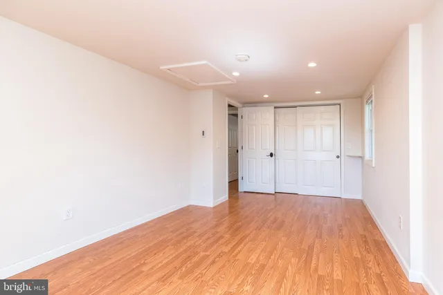 a view of a big room with wooden floor and windows