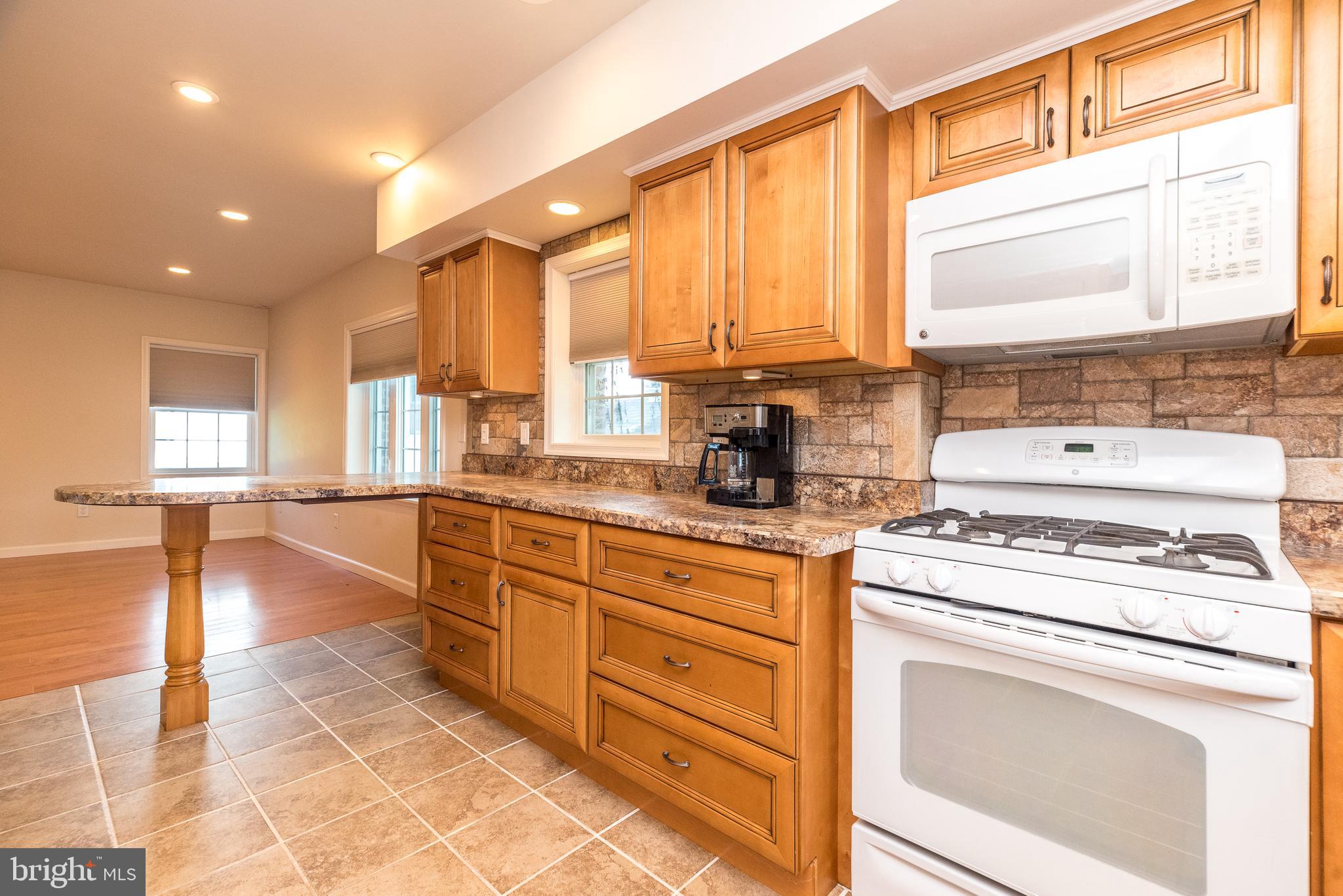 2478 River Road, Unit CARRIAGE New Hope, PA 18938 - Photo 3 of 23 a kitchen with a stove a sink and a refrigerator