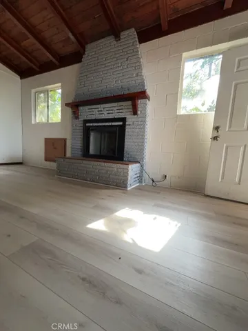 an empty room with windows and fireplace