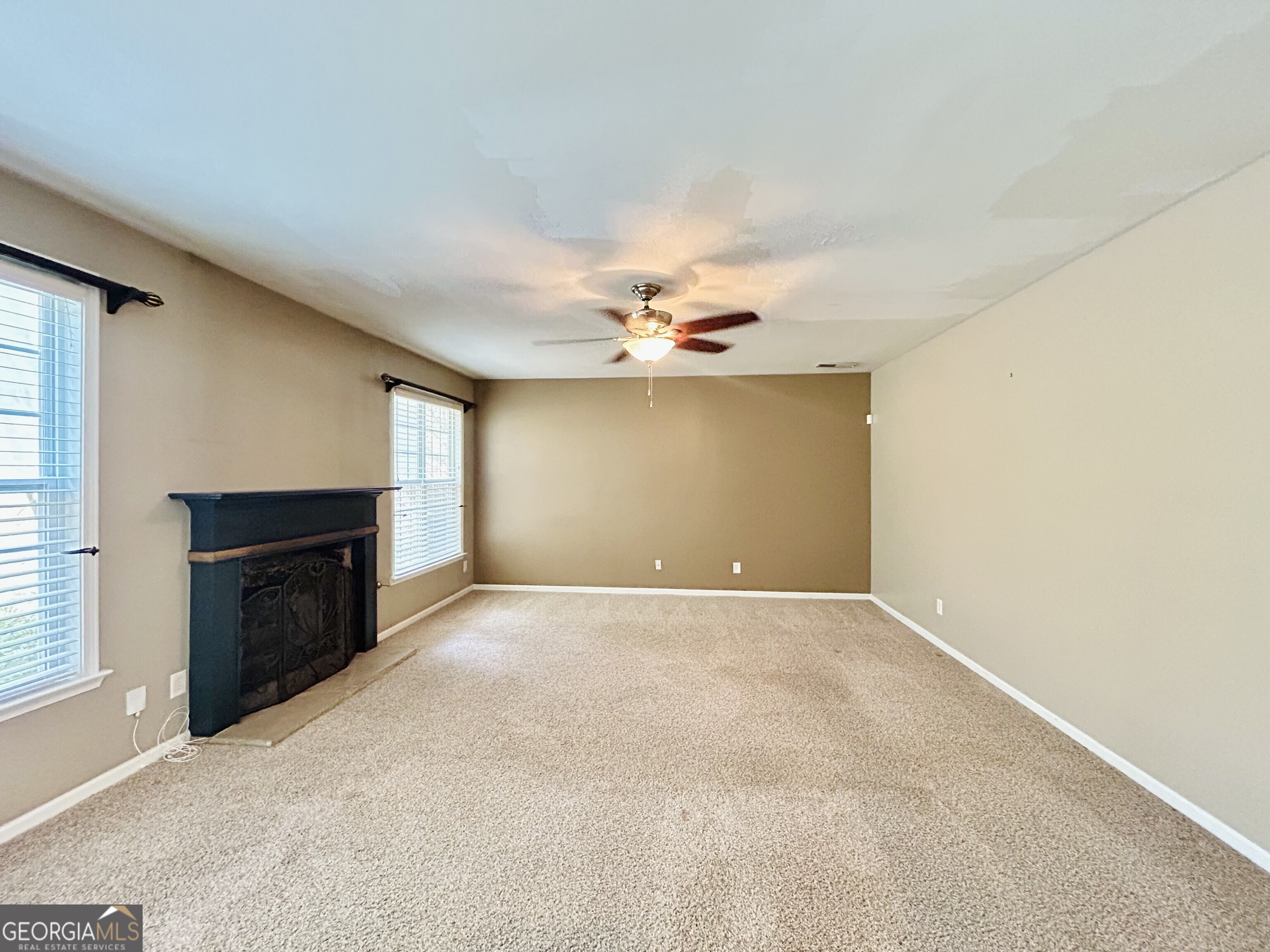 7613 Cedar Grove Court Fairburn, GA 30213 - Photo 18 of 61 an empty room with a fireplace and windows