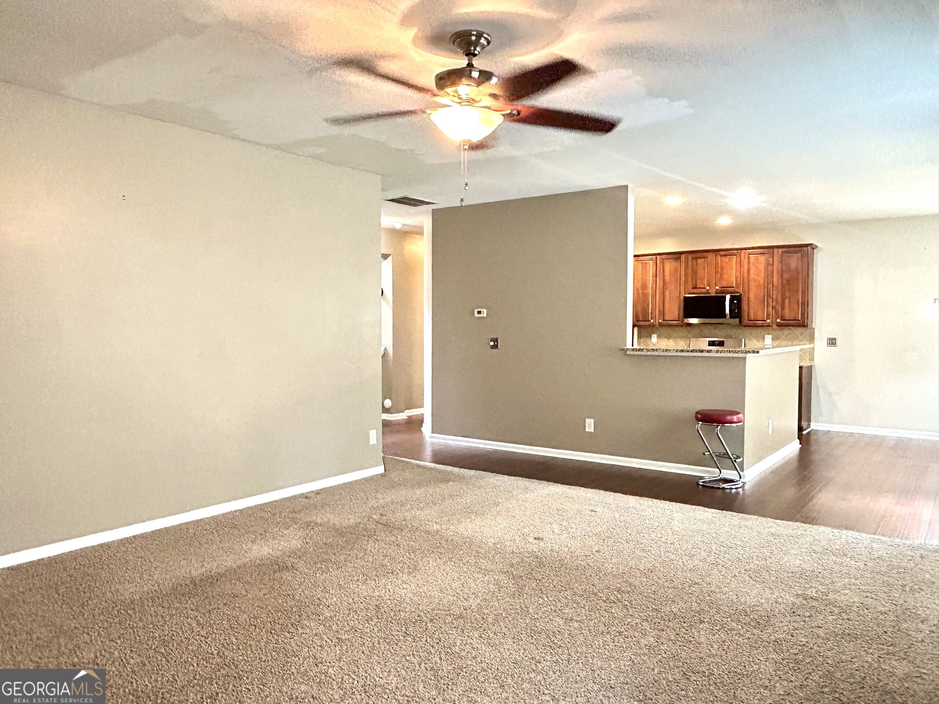 7613 Cedar Grove Court Fairburn, GA 30213 - Photo 20 of 61 a view of a livingroom with a chandelier fan and a kitchen