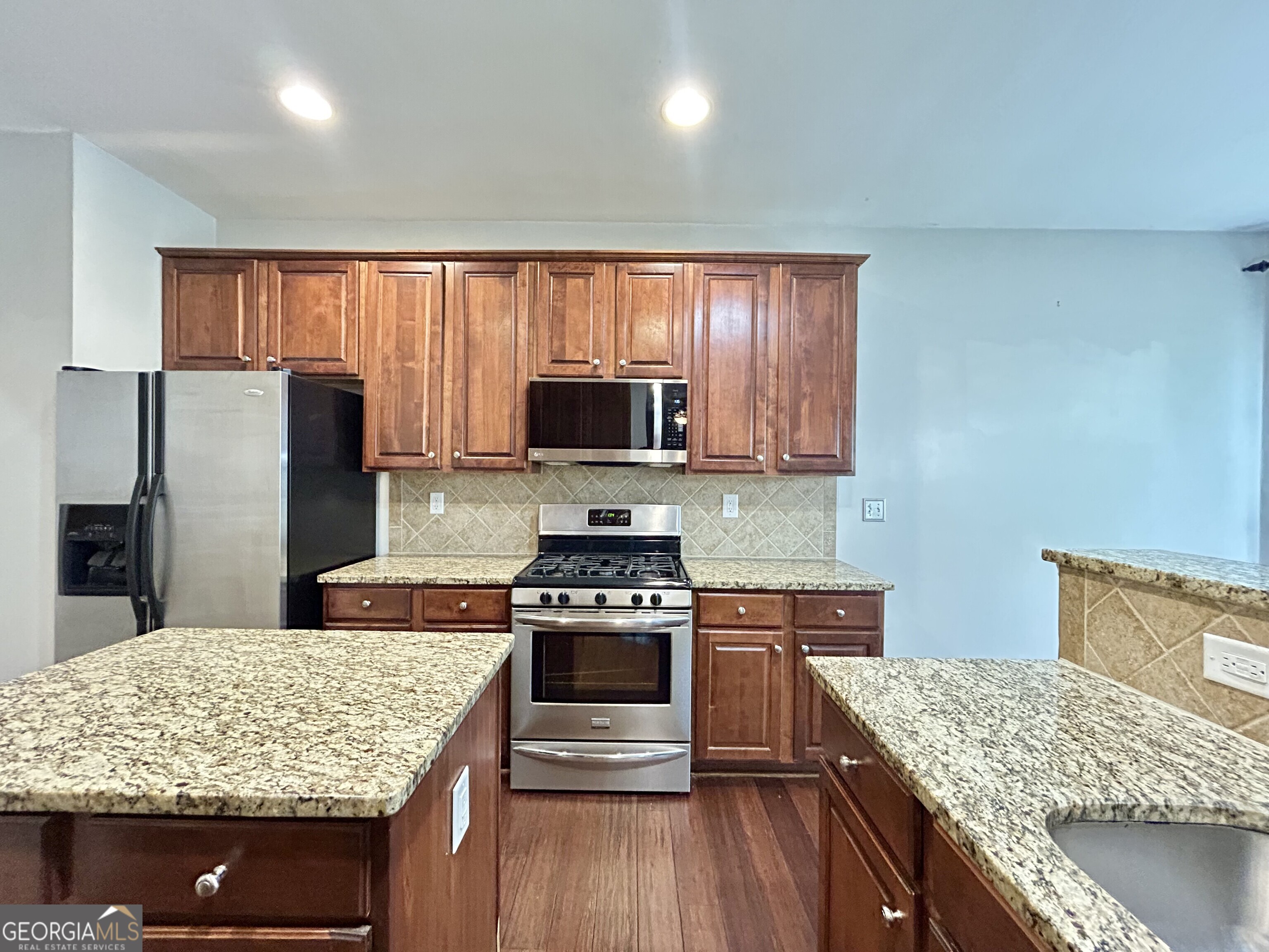7613 Cedar Grove Court Fairburn, GA 30213 - Photo 26 of 61 a kitchen with stainless steel appliances granite countertop hardwood floor sink stove and refrigerator