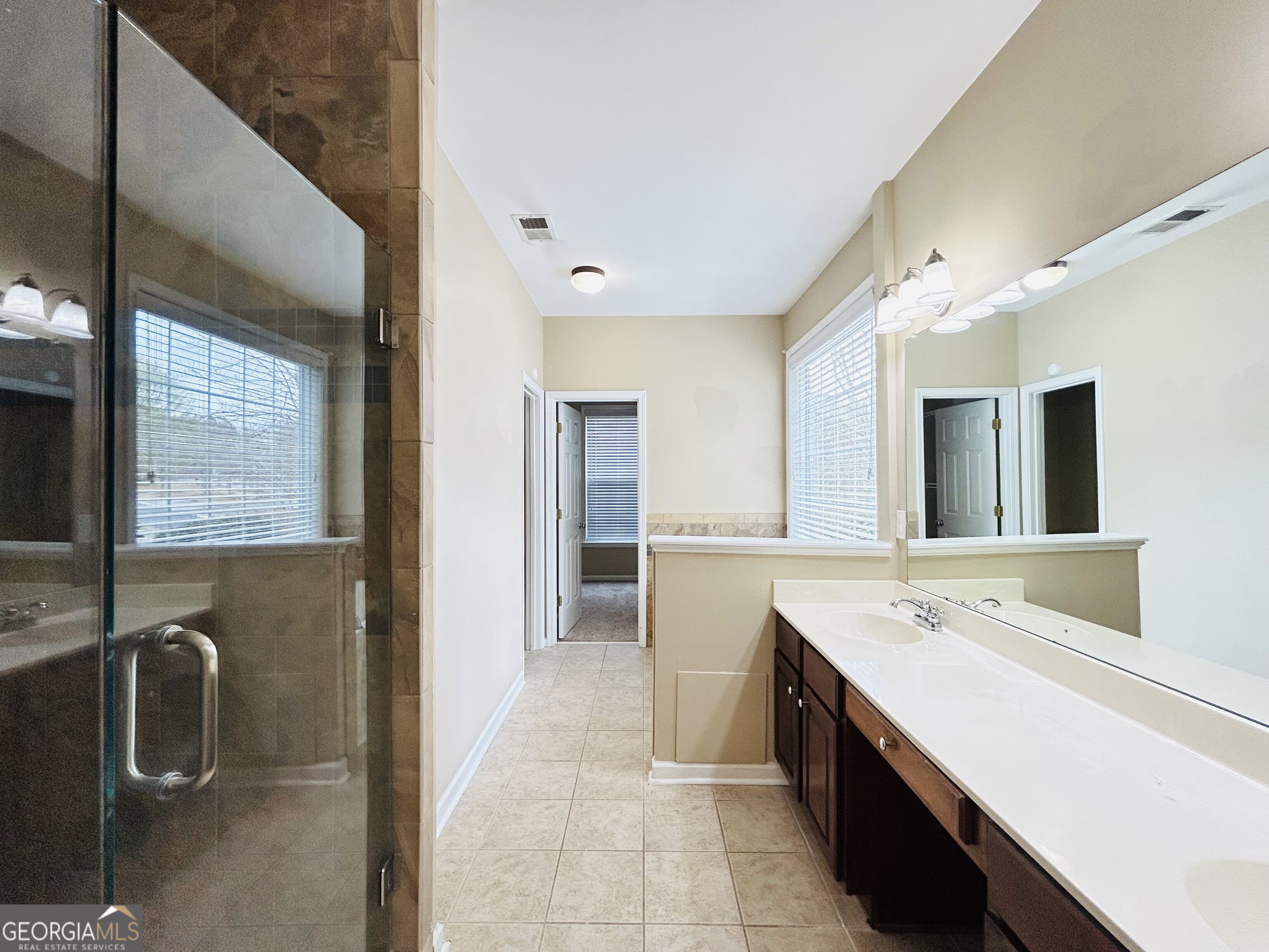 7613 Cedar Grove Court Fairburn, GA 30213 - Photo 35 of 61 a bathroom with a double vanity sink a mirror and bathtub
