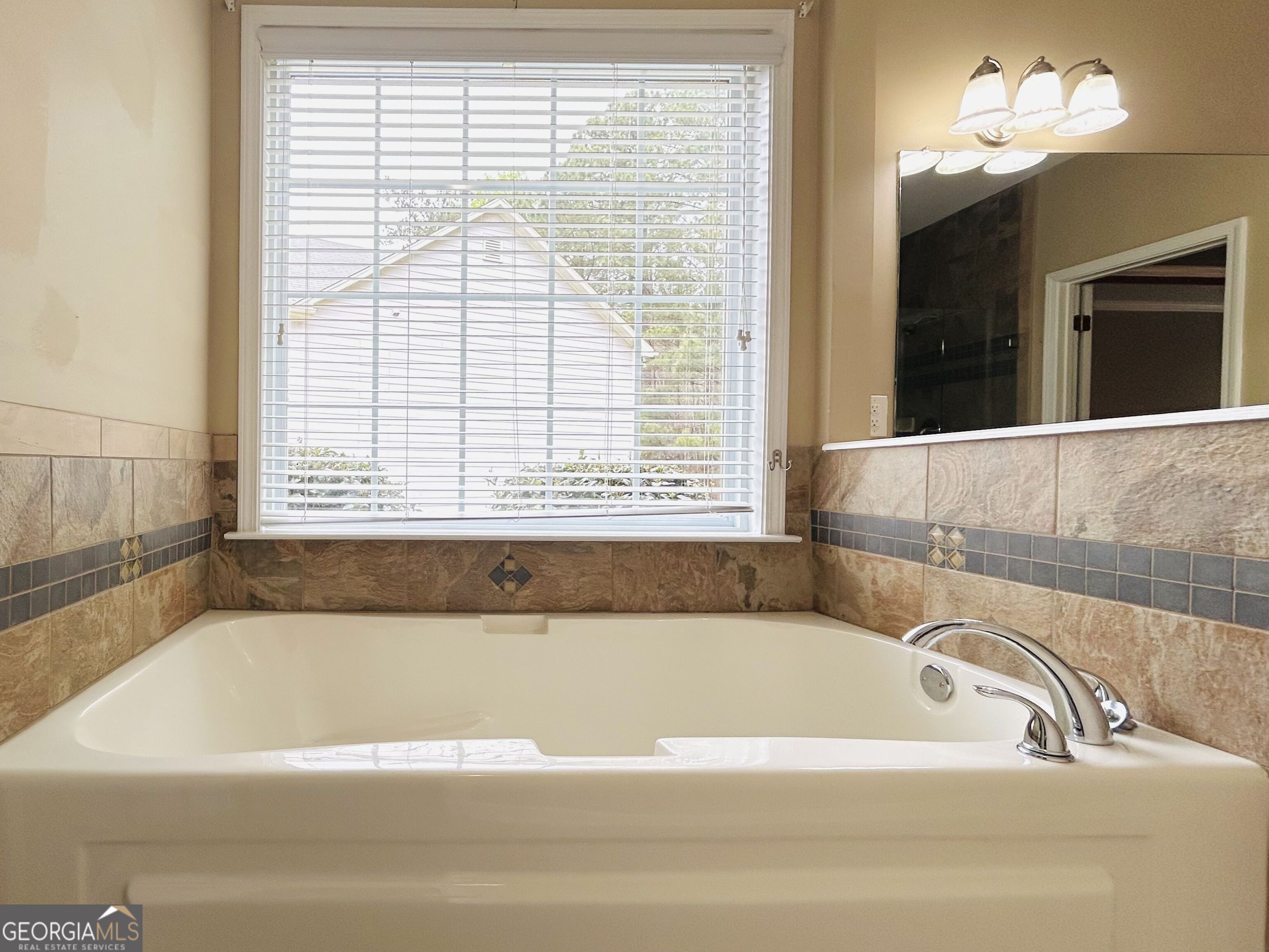 7613 Cedar Grove Court Fairburn, GA 30213 - Photo 40 of 61 a bathroom with a bathtub and next to a window