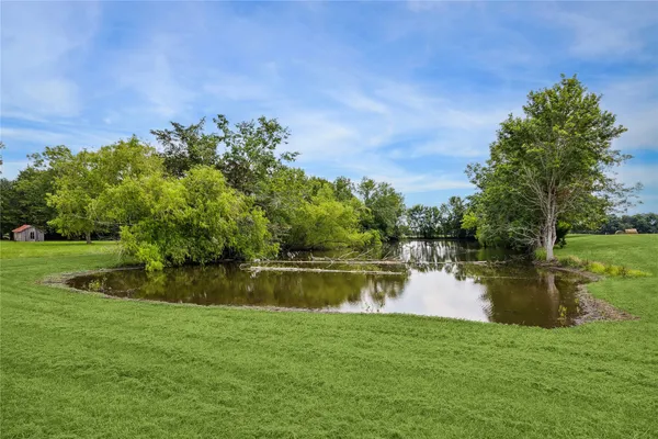a backyard of a house with lots of green space and lake view
