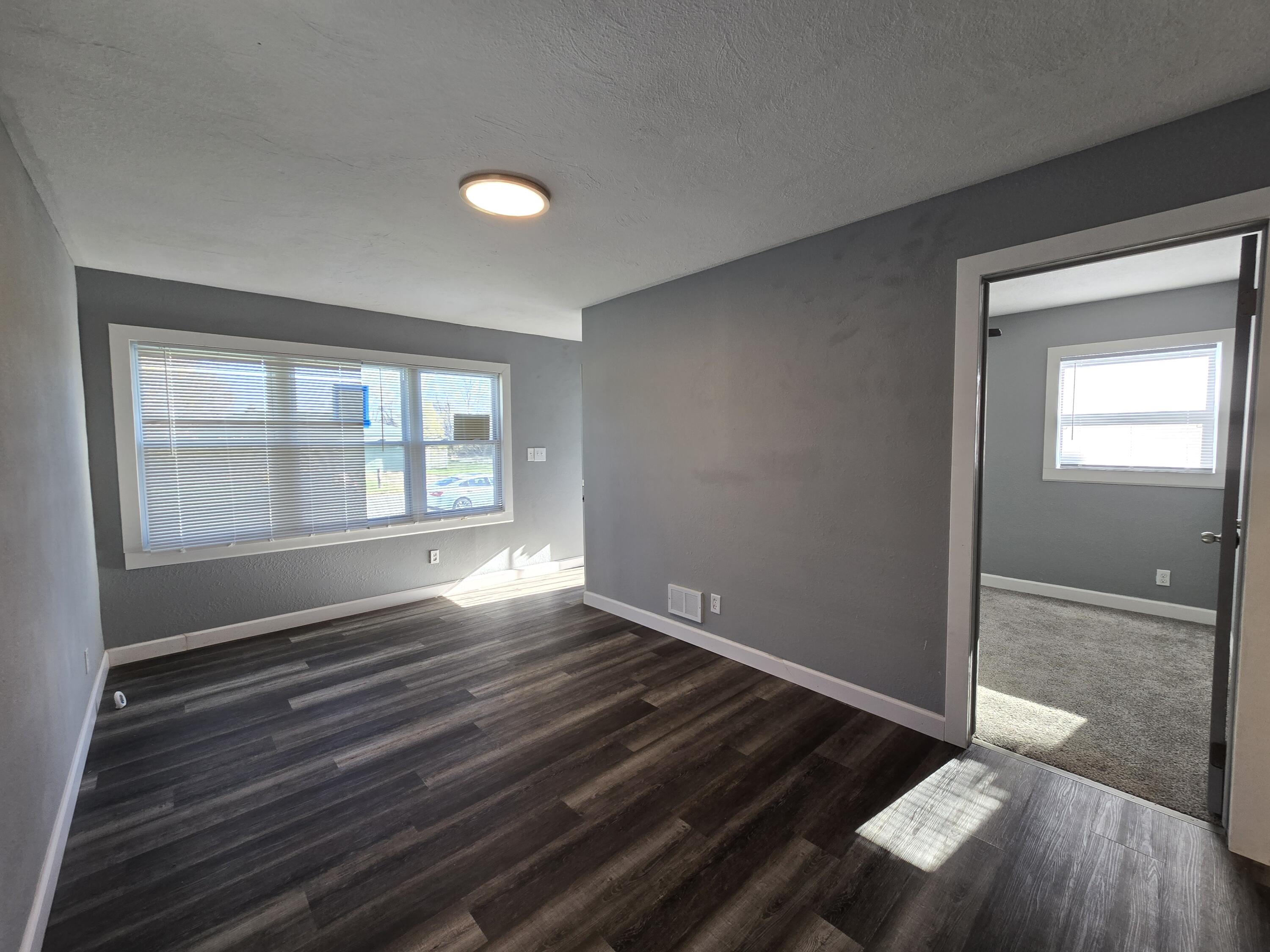 1622 Ohio Street Gary, IN 46407 - Photo 3 of 17 a view of an empty room with wooden floor and a window