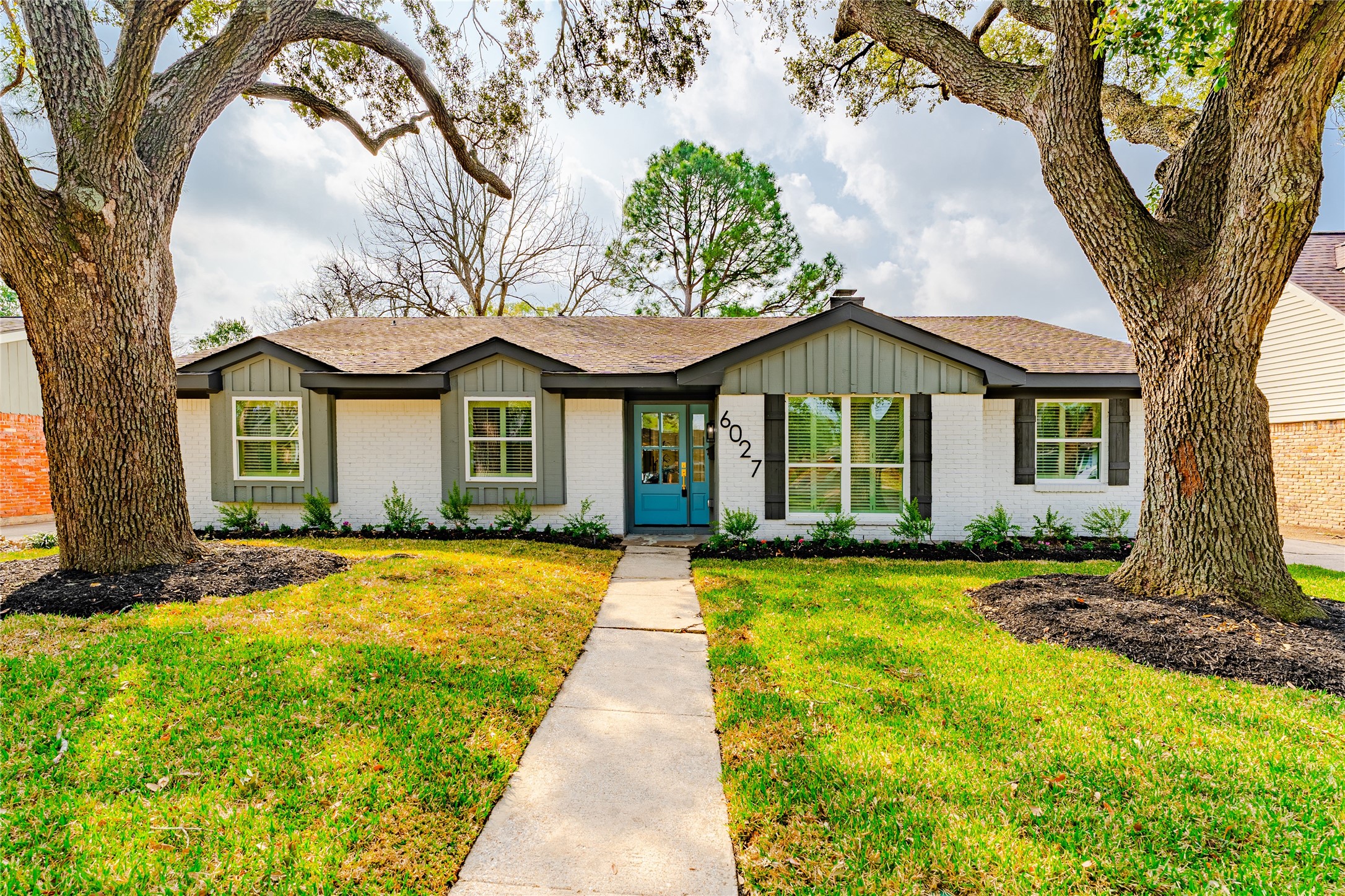 6027 Valkeith Drive Houston, TX 77096 - Photo 7 of 31 a front view of a house with a garden and trees