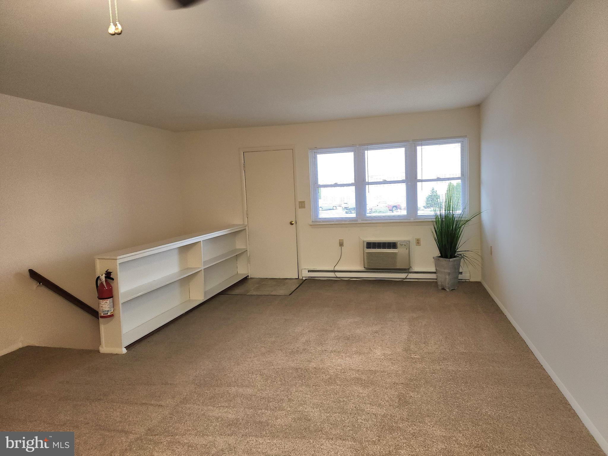 76 Lark Circle York, PA 17404 - Photo 5 of 28 an empty room with a fireplace and windows