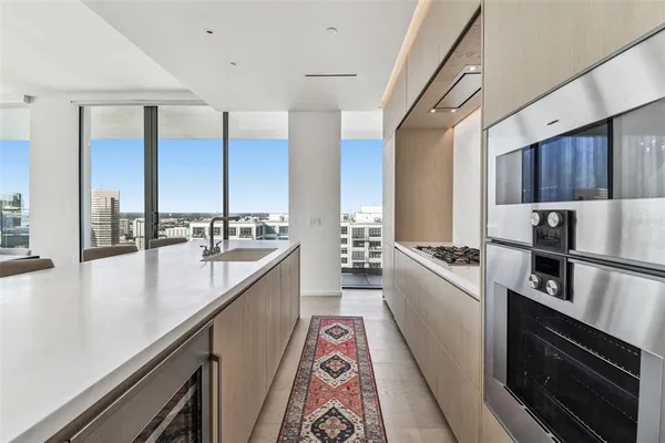a large kitchen with a refrigerator a sink a stove and cabinets