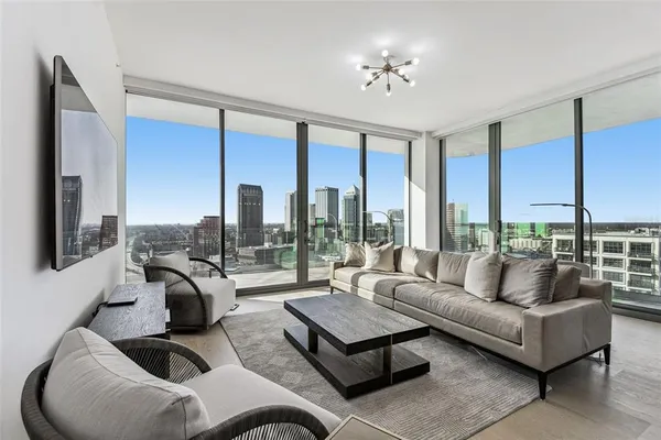 a living room with furniture and large windows