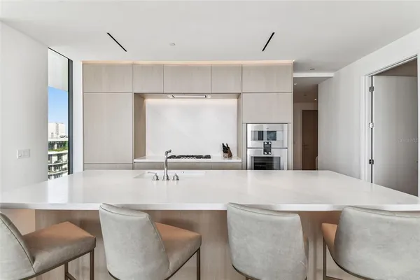 a living room with stainless steel appliances kitchen island granite countertop furniture and a large window