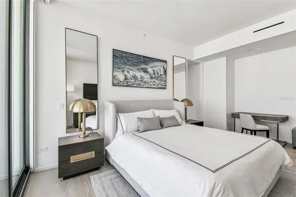 a bedroom with a bed and a painting on the wall