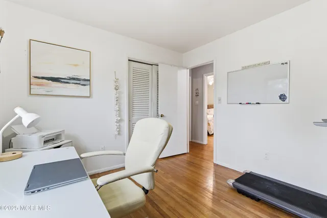 a view of a workspace with furniture and wooden floor