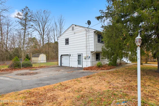 a view of a house with a yard and large tree