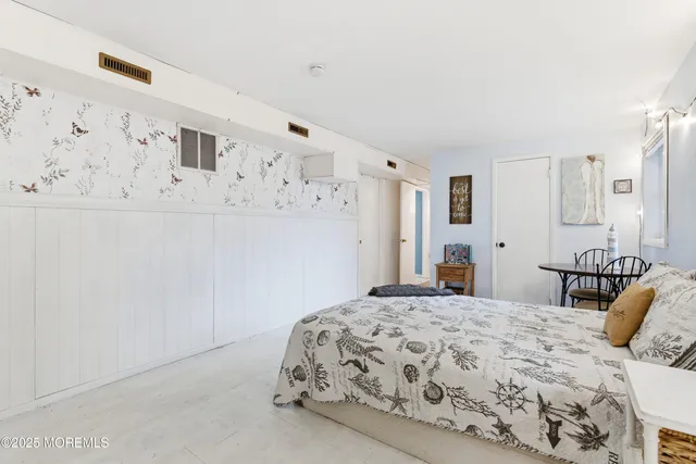 a bedroom with a bed and a white cabinet
