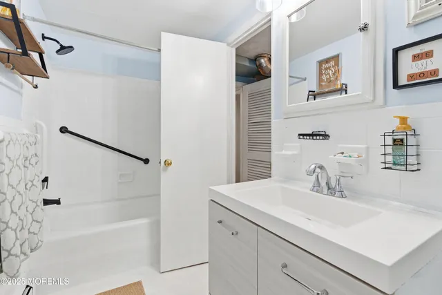 a bathroom with a tub sink and mirror