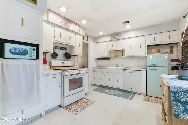 a kitchen with white cabinets and white appliances