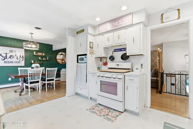 a kitchen with stainless steel appliances kitchen island granite countertop a table chairs and a refrigerator