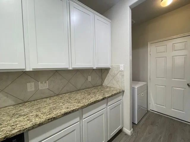 a kitchen with granite countertop cabinets and white stainless steel appliances