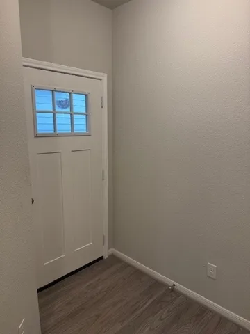 a view of a small space with wooden floor and a window