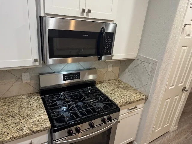 a stove top oven sitting inside of a kitchen