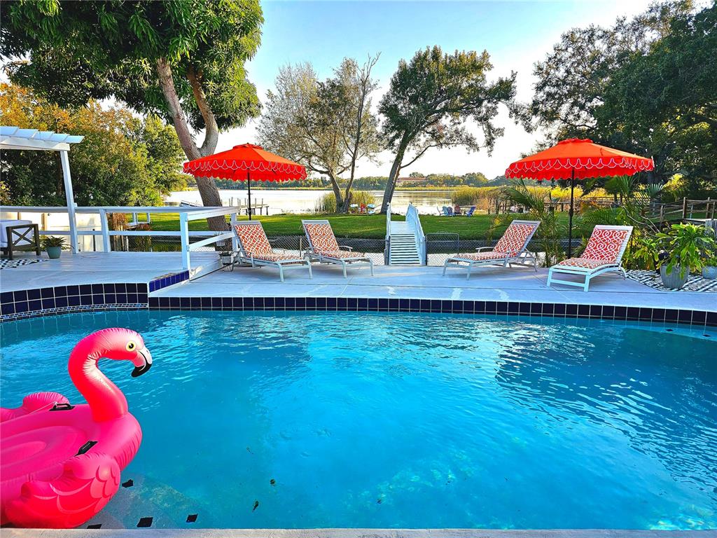 2153 Karan Way Clearwater, FL 33763 - Photo 52 of 65 a view of a lake with a table and chairs under an umbrella