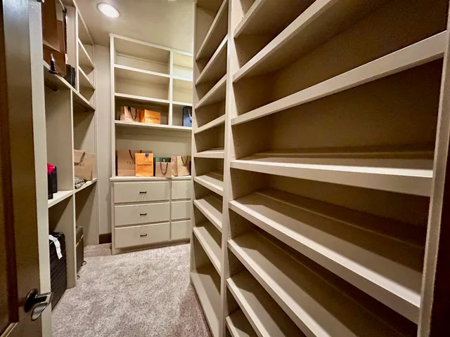 a view of walk in closet with clothes and shoes