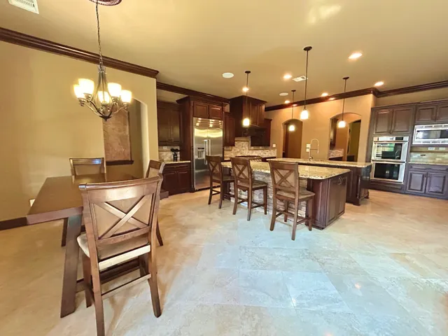 a view of a dining room with furniture and chandelier