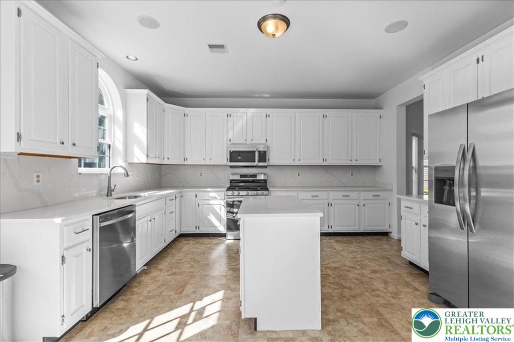 6832 Scenic View Drive Lower Macungie Township, PA 18062 - Photo 10 of 21 a kitchen with a sink a refrigerator and white cabinets