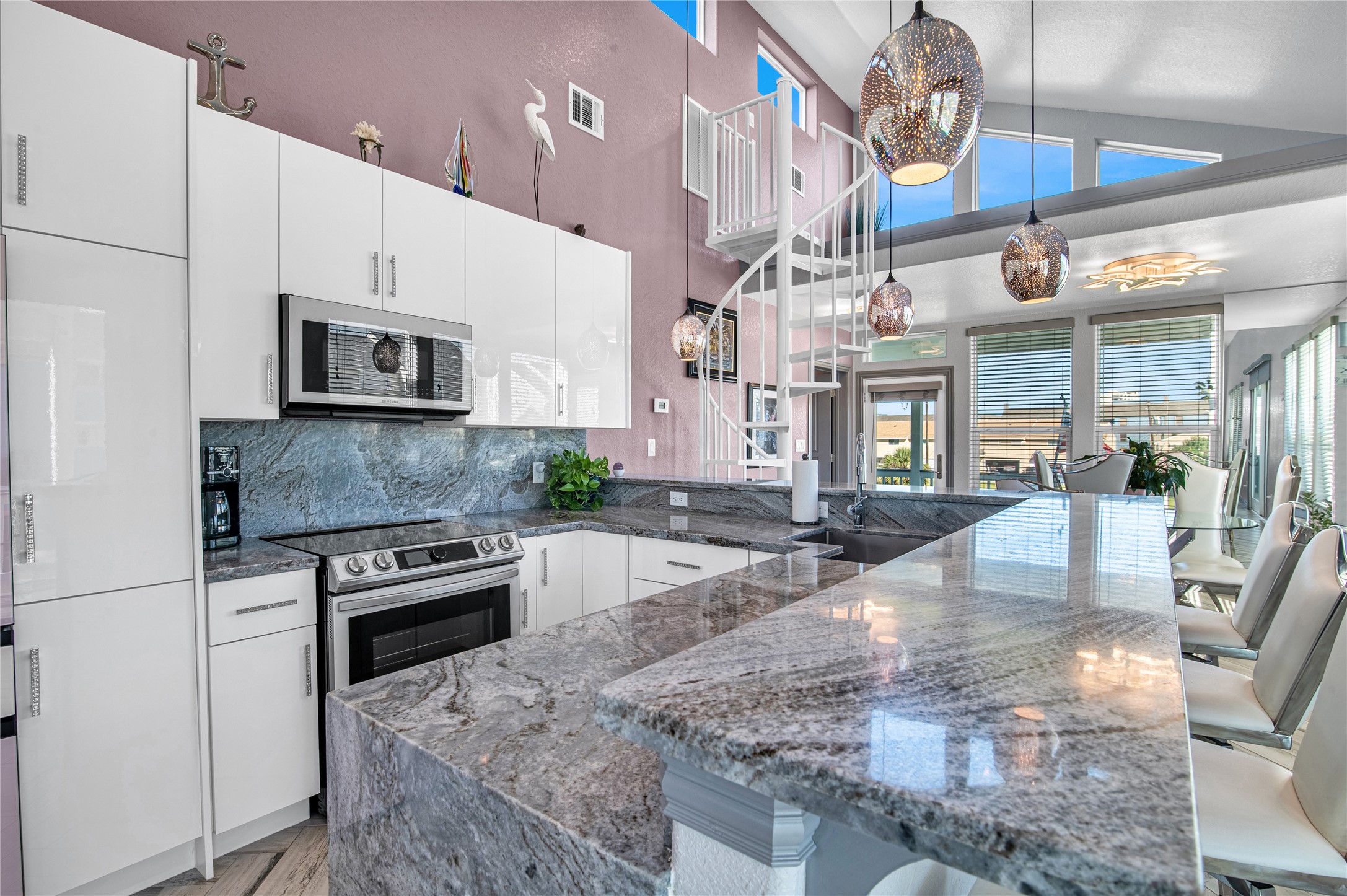 3709 Rice Street Galveston, TX 77554 - Photo 10 of 46 a large kitchen with stainless steel appliances granite countertop a stove a sink dishwasher and a microwave oven with white cabinets