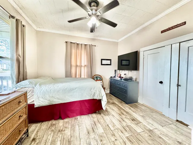 a spacious bedroom with a bed and a flat screen tv