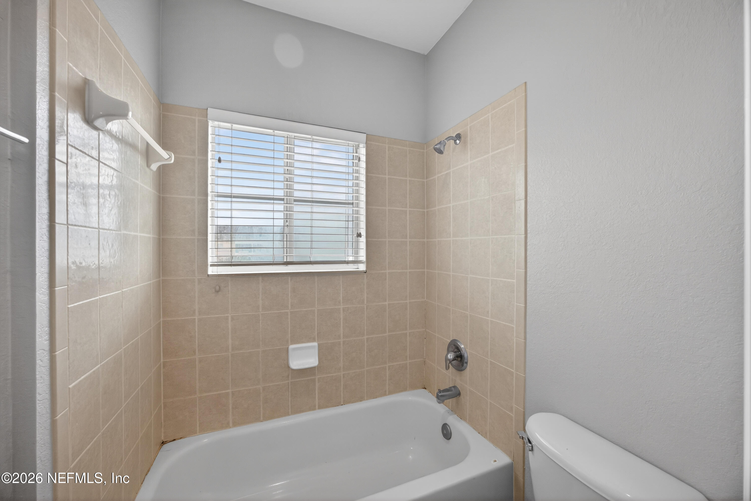 9745 Touchton Road, Unit 1224 Jacksonville, FL 32246 - Photo 15 of 22 a bathroom with a bathtub a window and a shower