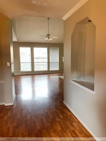 a view of a room with wooden floors and windows