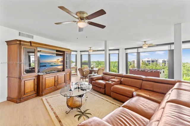 a living room with furniture a flat screen tv and a large window