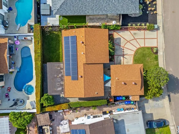 an aerial view of a house with a yard and a large tree