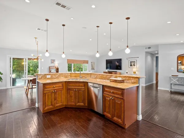a kitchen with stainless steel appliances granite countertop wooden floors and sink