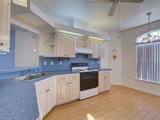 a kitchen with white cabinets and appliances