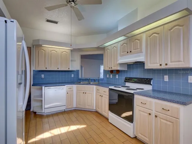 a kitchen with stainless steel appliances granite countertop a stove a sink and a refrigerator