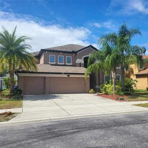 a front view of a house with a yard and palm tree