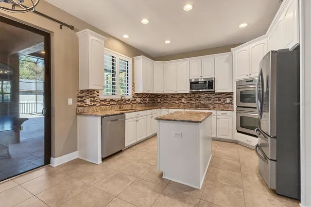 a kitchen with granite countertop a sink and a refrigerator