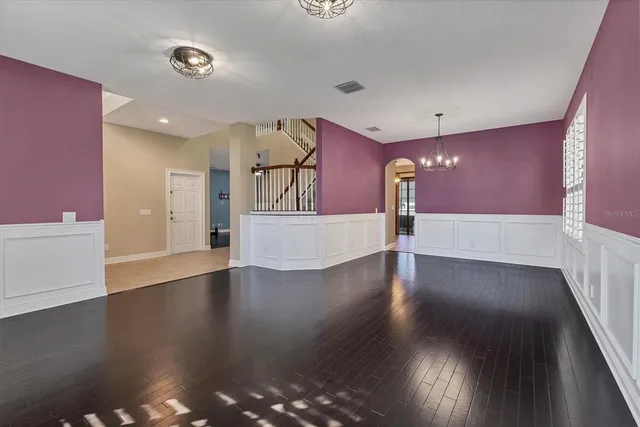 a view of a kitchen with refrigerator and white cabinets