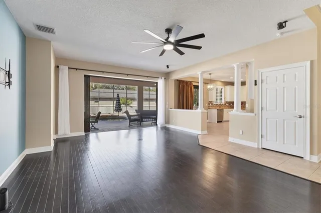 an empty room with wooden floor and windows