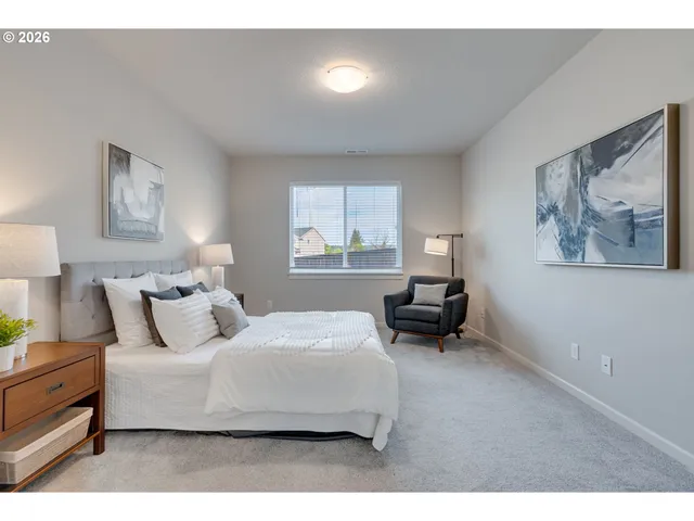 a bedroom with a bed and a painting on the wall