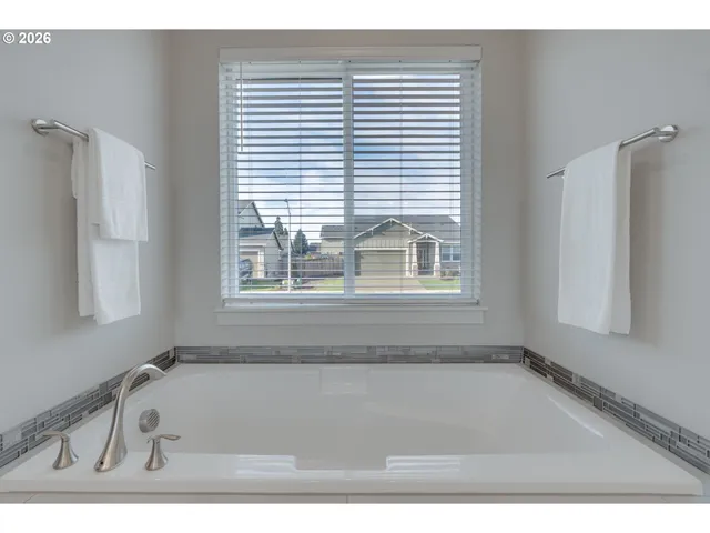 a bathroom with a tub a sink and a window