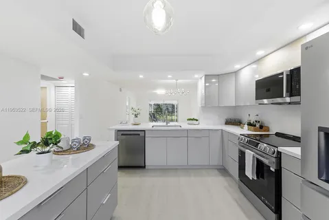 a kitchen with white cabinets and stainless steel appliances